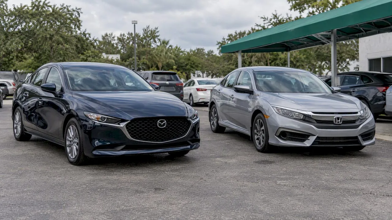Mazda3 and Civic parked at a dealership