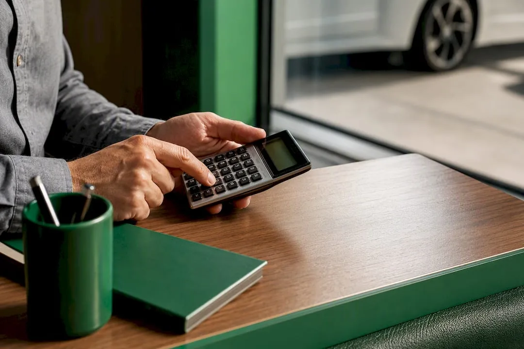 Calculator beside vehicle key at finance desk